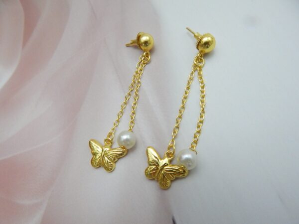 A pair of gold-tone ball stud earrings with a chain drop featuring a butterfly charm and a white pearl.