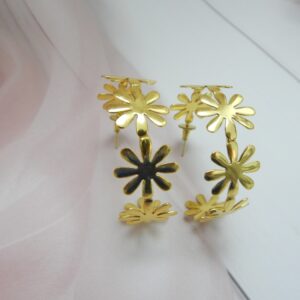 Large, bright gold-tone hoop earrings made entirely of linked daisy flower shapes.