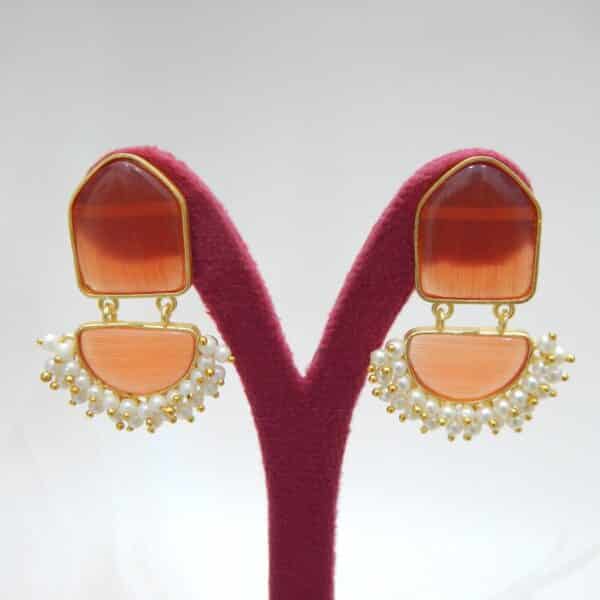 Navratri Orange Jewellery - Royal Reflection DS Pearl cluster dangler earrings with orange geometric stone and half-moon drop on a display stand
