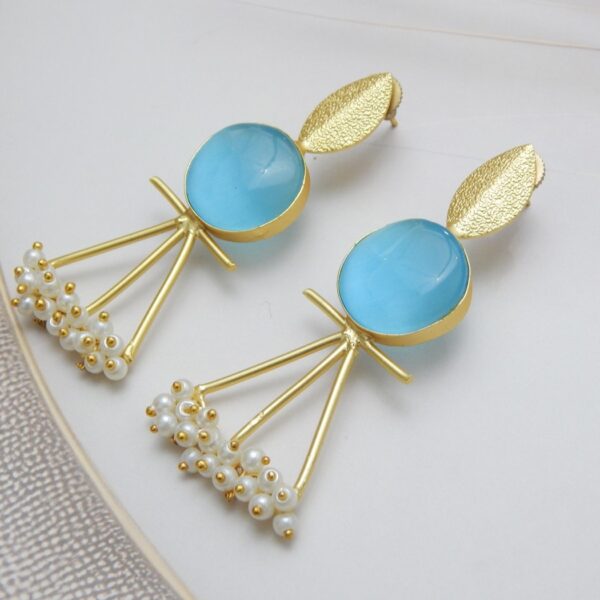 A pair of gold-tone artistic earrings with a leaf stud, a large round aqua blue stone, and a cluster of pearl dangles.