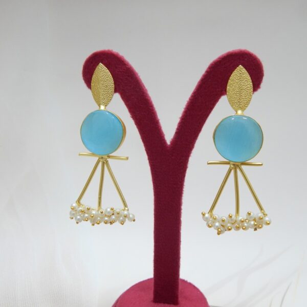 A pair of gold-tone artistic earrings with a leaf stud, a large round aqua blue stone, and a cluster of pearl dangles.