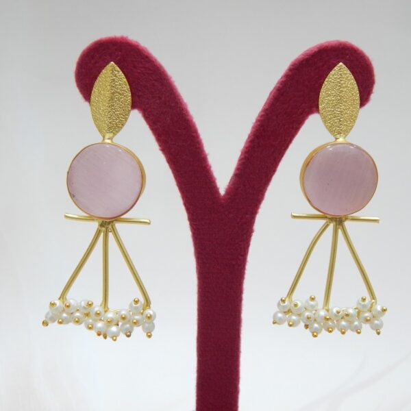 A pair of gold-tone artistic earrings with a leaf stud, a large round pink stone, and a cluster of pearl dangles.