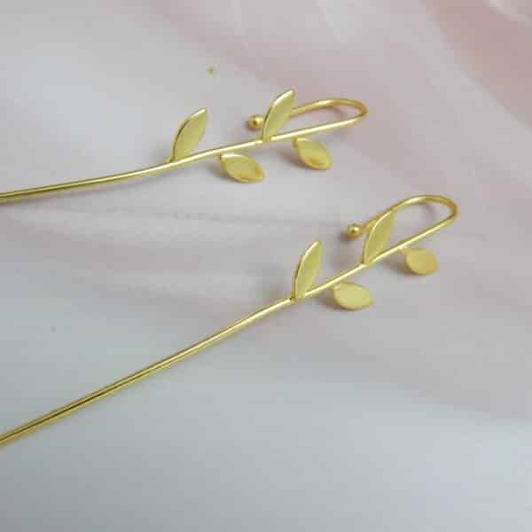 Gold-tone minimalist leaf earrings with four leaves along a slim bar and hook ear wire