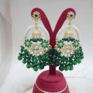 A pair of gold Kundan jhumka earrings with a half-moon design and dark green beaded drops