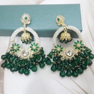 A pair of gold Kundan jhumka earrings with a half-moon design and dark green beaded drops
