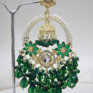 A pair of gold Kundan jhumka earrings with a half-moon design and dark green beaded drops