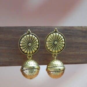A pair of gold-toned ethnic earrings with a circular sunburst stud and a hammered bell-shaped dangle below