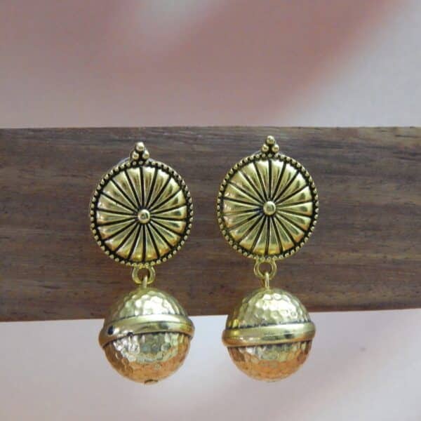 A pair of gold-toned ethnic earrings with a circular sunburst stud and a hammered bell-shaped dangle below