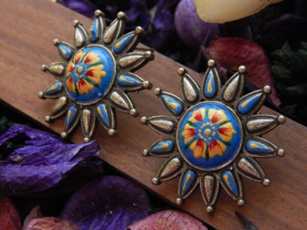 A pair of antique-silver sunburst stud earrings with a colorful Meenakari floral design.