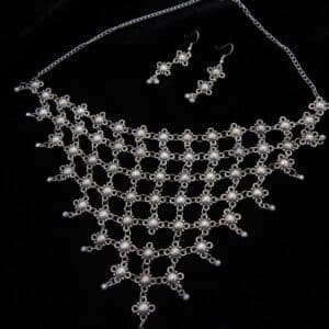 Wide German Silver choker necklace with mesh/net pattern of small oxidized floral links and matching hook earrings on a black background.