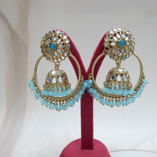 A pair of large, traditional hoop jhumka earrings with intricate mirror work on the top stud and bell, and a cluster of dangling aqua colored beads on the bottom.
