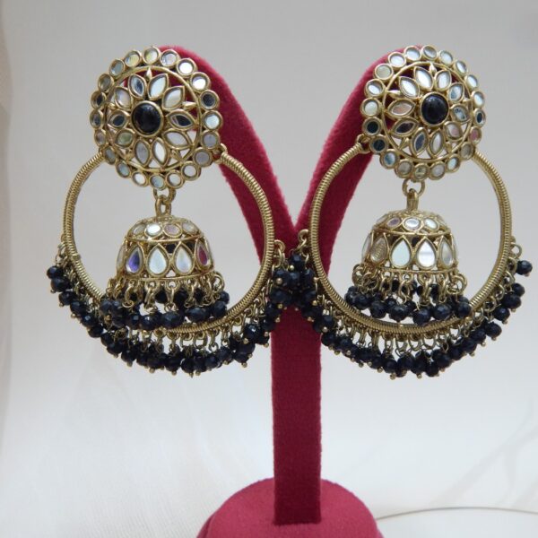 A pair of large, traditional hoop jhumka earrings with intricate mirror work on the top stud and bell, and a cluster of dangling black colored beads on the bottom.