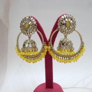 A pair of large, traditional hoop jhumka earrings with intricate mirror work on the top stud and bell, and a cluster of dangling yellow colored beads on the bottom.
