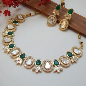 A traditional Indian Kundan Polki choker and earring set with a combination of clear and dark green teardrop-shaped stones and a gold-toned finish.