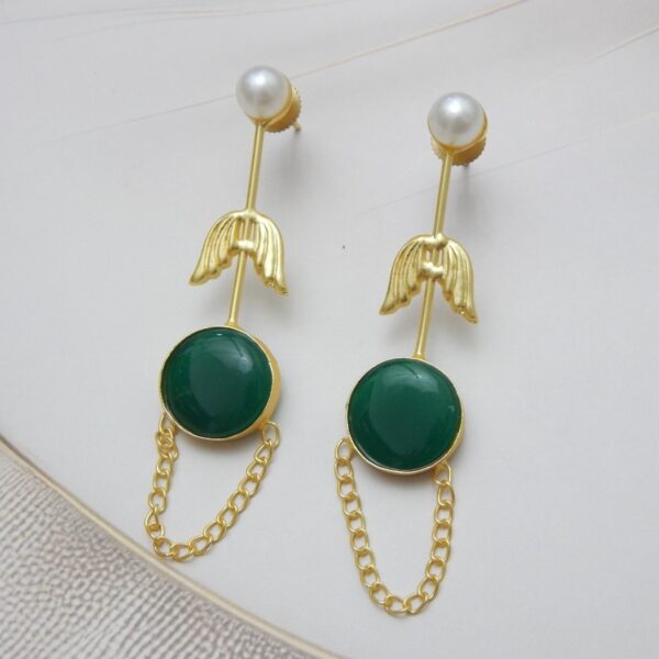 A pair of long gold-tone arrow-design earrings with a pearl stud, a round green colored stone, and a delicate chain loop.