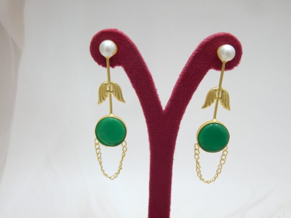 A pair of long gold-tone arrow-design earrings with a pearl stud, a round green colored stone, and a delicate chain loop.
