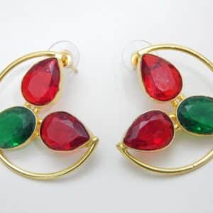 Large gold-tone crescent earrings with two red teardrop stones and one green oval stone.