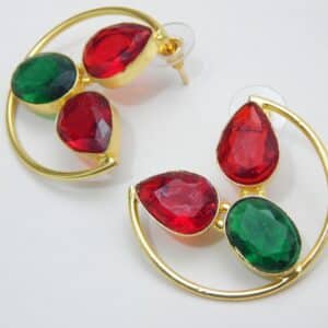 Large gold-tone crescent earrings with two red teardrop stones and one green oval stone.