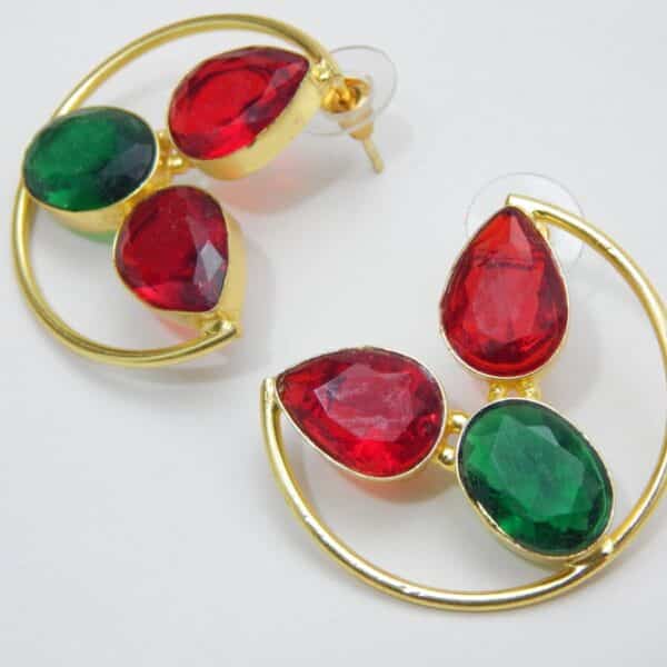 Large gold-tone crescent earrings with two red teardrop stones and one green oval stone.