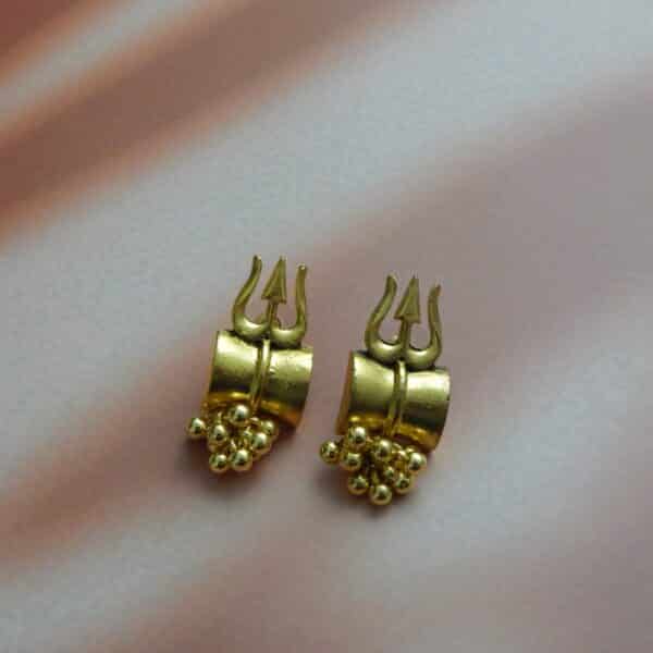 A pair of small, antique gold-toned earrings with a Trishul (trident) design and a cluster of gold beads hanging below