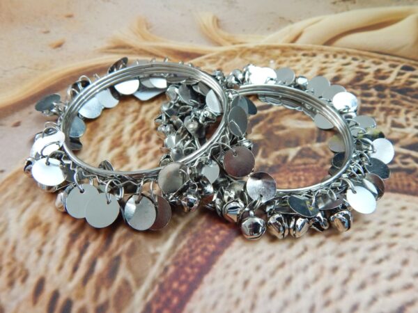 Pair of silver wire bangles adorned with tiny dangling ghungroo bells and circular coin charms, suitable for college students and festive wear.