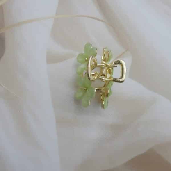top view of Small gold-toned hair claw clip with a cluster of mint green faceted floral stones, elegant hair accessory for women.
