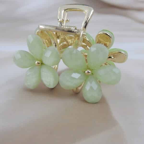 zoom of Small gold-toned hair claw clip with a cluster of mint green faceted floral stones, elegant hair accessory for women.