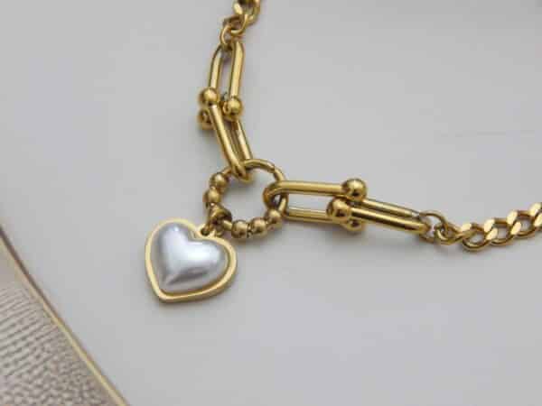 Close-up of heart charm chain bracelet in gold finish – Royal Reflection Dazzling Studio