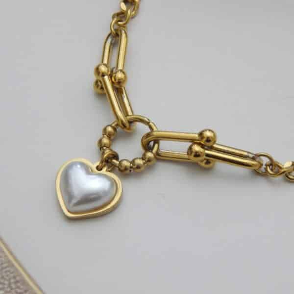 Close-up of heart charm chain bracelet in gold finish – Royal Reflection Dazzling Studio