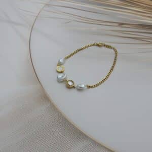 Full view of pearl and Roman charm gold bracelet on display – Royal Reflection Dazzling Studio