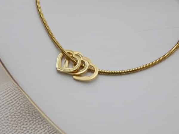 Close-up of gold snake chain bracelet with interlocked heart design – Royal Reflection Dazzling Studio