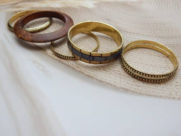 Antique gold and wood-finish stacked bangles set with beaded and embossed detailing – Aaravi Stacked Bangles Set.