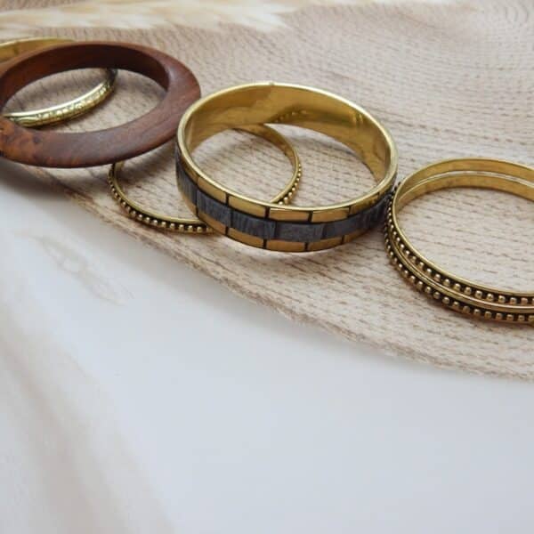 Antique gold and wood-finish stacked bangles set with beaded and embossed detailing – Aaravi Stacked Bangles Set.