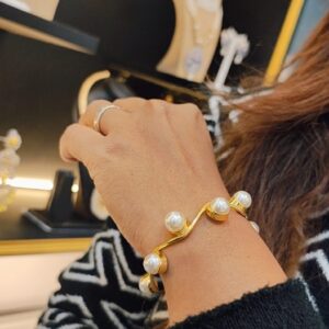 Gold-plated wavy design kada with round pearl accents – Aarika Wave Pearl Kada.