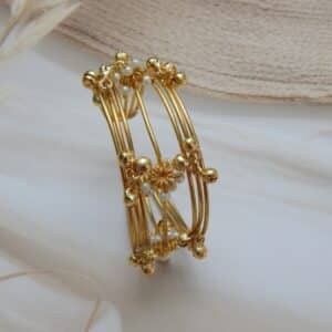 Multi-strand gold-plated kada/cuff with dangling ghungroos and small white pearls, designed in a traditional temple style.