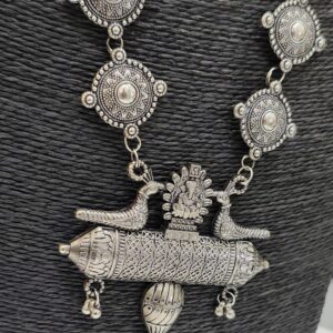 Close up of oxidised peacock pendant necklace with detailed carvings and round motif chain