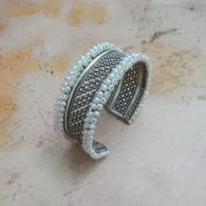 Oxidised silver jali cuff bracelet with pearl border — angled view showing full band