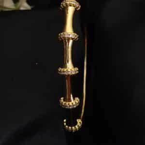 clode up of Bamboo anti tarnish kada for women in gold-toned segmented design with American diamond stones