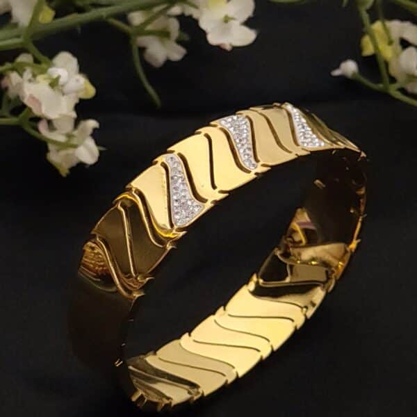side view of a Wave anti tarnish kada for women in gold-toned diagonal wave design with American diamond stones