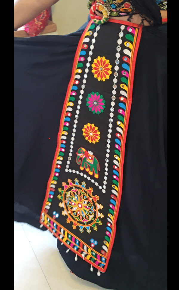 Black embroidered lehenga belt with long hanging panel worn at the waist for garba