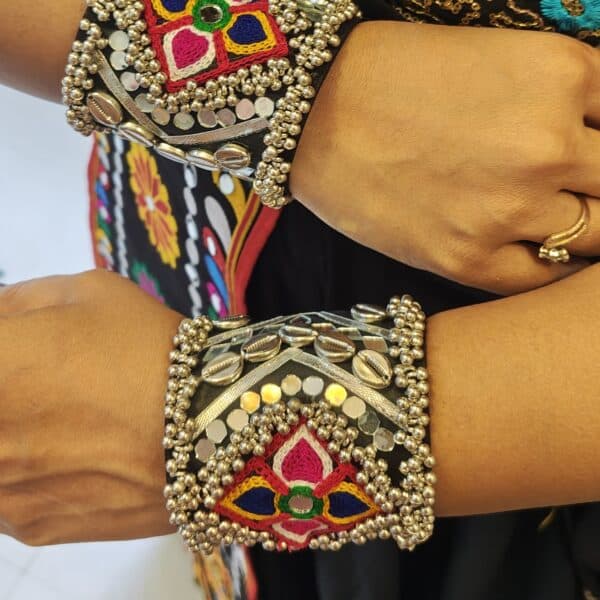 Black ghungroo cuff bracelet with embroidered mirror motif worn on the wrist for garba