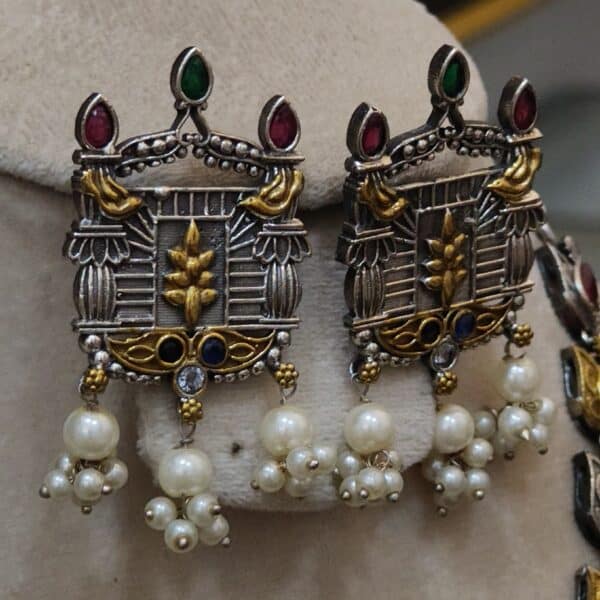 Matching dual-tone jharokha-style earrings with pearl fringe and multicolour stones